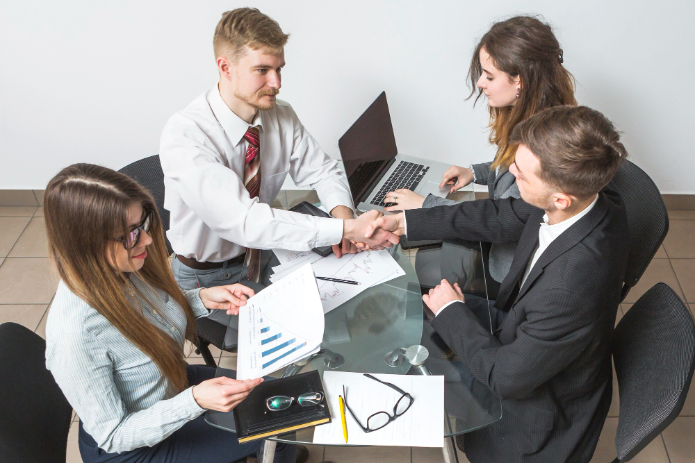 businessman shaking hands with his partner at workplace
